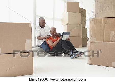 Older Black couple relaxing in new home View Large Photo Image Stock Photograph - Older Black couple relaxing in new home. Fotosearch