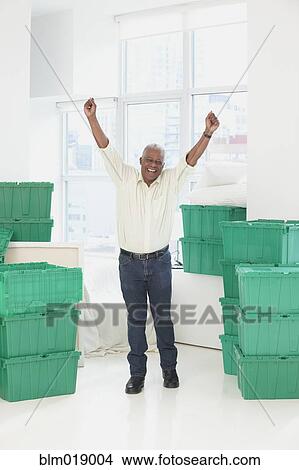 Older Black man cheering in new home View Large Photo Image Picture - Older Black man cheering in new home. Fotosearch