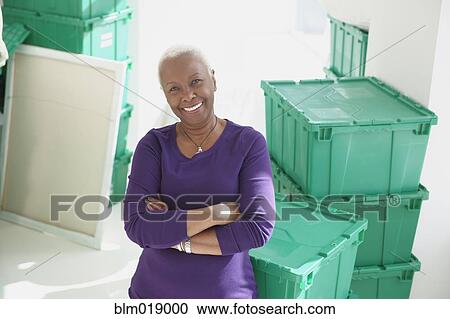 Stock Image - Older Black woman smiling in new home. Fotosearch