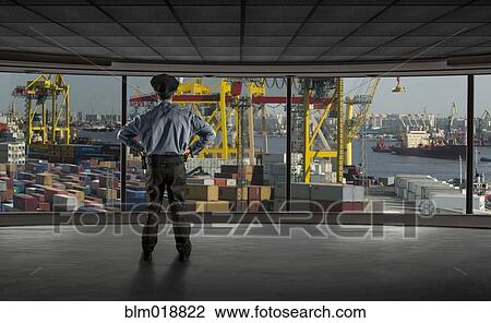 Stock Image - Police officer overlooking shipyard. Fotosearch