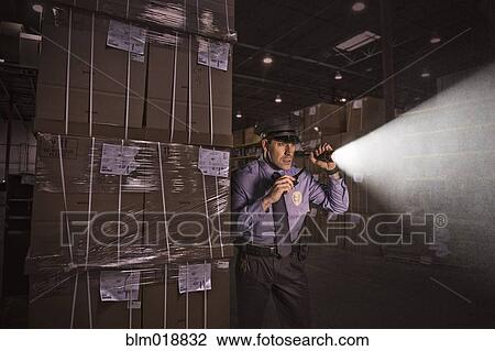 Police officer shining flashlight in warehouse View Large Photo Image Stock Image - Police officer shining flashlight in warehouse. Fotosearch