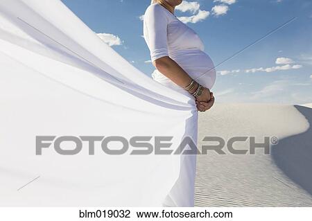 Stock Image - Pregnant Caucasian woman in desert. Fotosearch