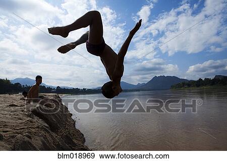 Stock Photo - Silhouette of boy jumping into river. Fotosearch