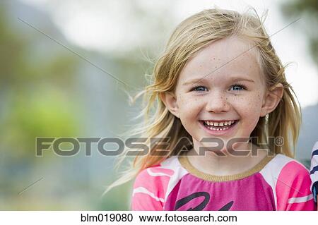 Stock Image - Smiling girl standing outdoors. Fotosearch