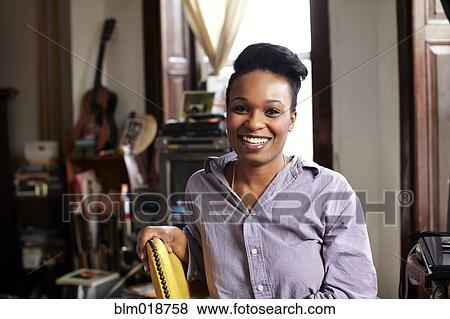 Stock Photo - Smiling woman sitting indoors. Fotosearch