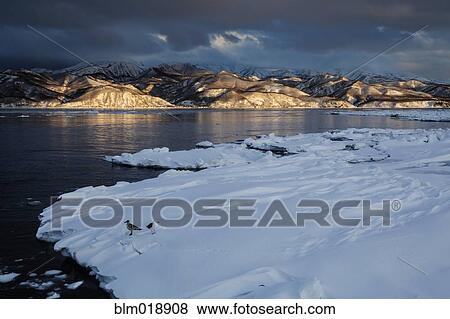 Stock Photo - Sun hitting snowy Shiretoko Peninsula, Rausu, Hokkaido, Japan. Fotosearch