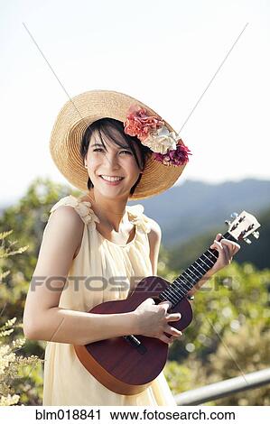 Thai woman playing ukulele outdoors View Large Photo Image Stock Image - Thai woman playing ukulele outdoors. Fotosearch