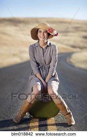 Thai woman sitting on suitcase on rural road View Large Photo Image Stock Image - Thai woman sitting on suitcase on rural road. Fotosearch