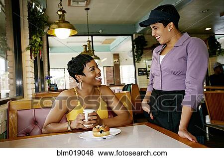Stock Photo - Waitress talking to customer in restaurant. Fotosearch