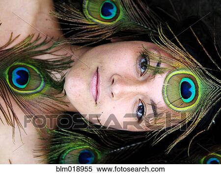 Stock Photography - Woman surrounded by peacock feathers. Fotosearch