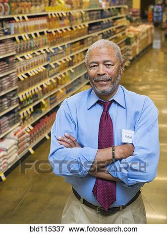 Stock Photo - African American businessman smiling in grocery store. Fotosearch