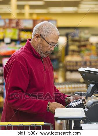 Stock Photo - African American customer at grocery store checkout. Fotosearch