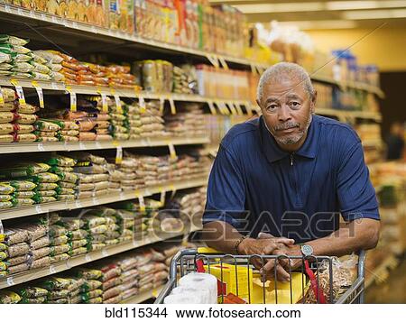 Picture - African American man smiling in grocery store. Fotosearch