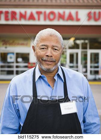 Stock Photography - African American worker smiling outside grocery store. Fotosearch