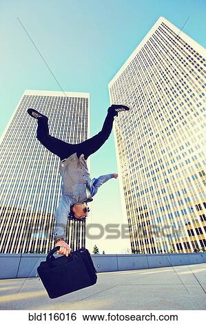 Asian businessman doing back flip on urban rooftop View Large Photo Image Stock Photograph - Asian businessman doing back flip on urban rooftop. Fotosearch
