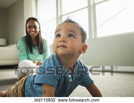 Stock Image - Baby boy crawling in living room. Fotosearch