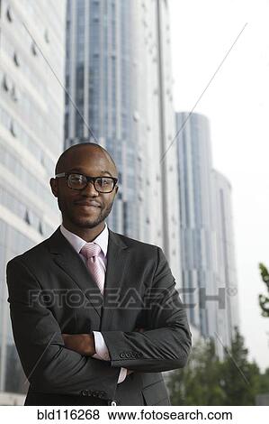Stock Photo - Black businessman smiling on city street. Fotosearch