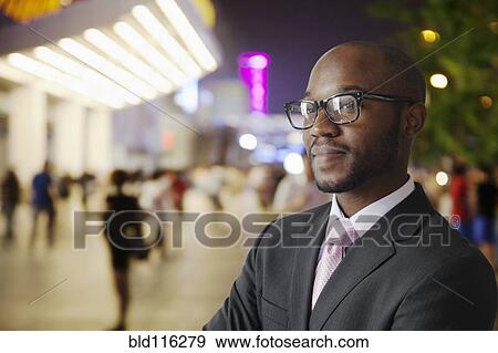 Stock Photo - Black businessman smiling on city street. Fotosearch