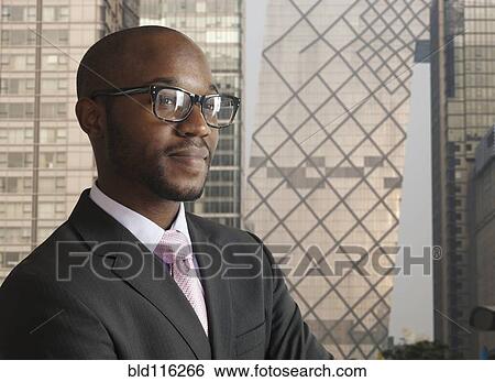 Stock Photograph - Black businessman smiling on city street. Fotosearch