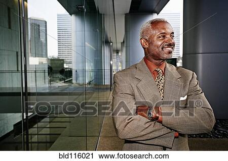 Stock Image - Black businessman smiling outdoors. Fotosearch