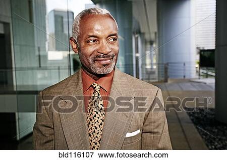 Stock Photo - Black businessman smiling outside office. Fotosearch