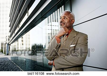 Stock Photo - Black businessman smiling outside office. Fotosearch