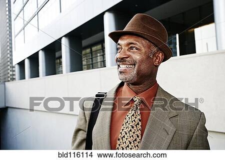 Black businessman standing on city street View Large Photo Image Picture - Black businessman standing on city street. Fotosearch