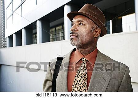 Stock Image - Black businessman standing on city street. Fotosearch