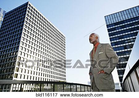 Black businessman standing on urban walkway View Large Photo Image Stock Photo - Black businessman standing on urban walkway. Fotosearch