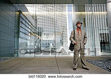 Stock Image - Black businessman standing outside office. Fotosearch