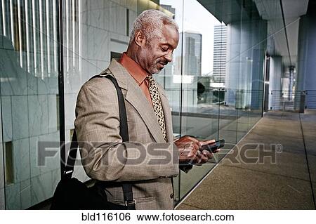 Stock Photograph - Black businessman using cell phone. Fotosearch