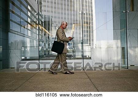Stock Photography - Black businessman using cell phone. Fotosearch