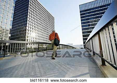Stock Photo - Black businessman walking on urban walkway. Fotosearch