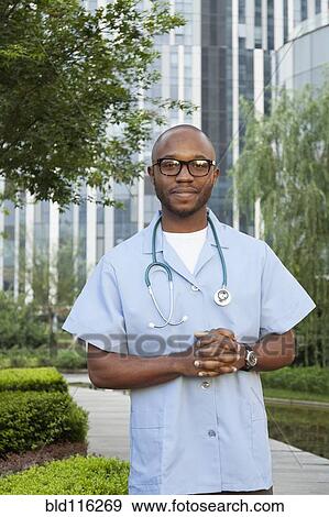 Stock Photo - Black doctor smiling in urban park. Fotosearch