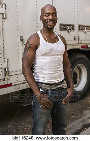 Black man smiling by truck View Large Photo Image Stock Photo - Black man smiling by truck. Fotosearch