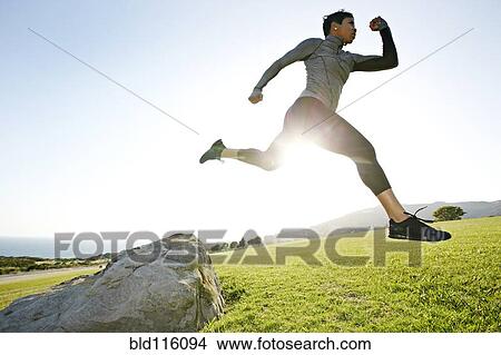 Picture - Black woman running in rural landscape. Fotosearch
