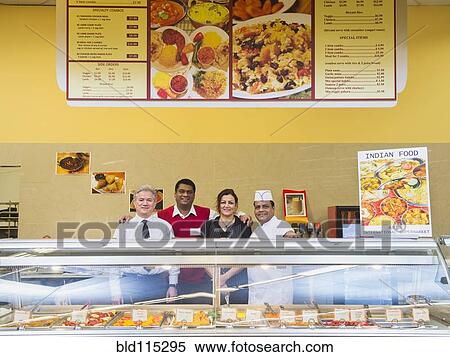 Stock Photography - Business people and chefs behind restaurant counter. Fotosearch