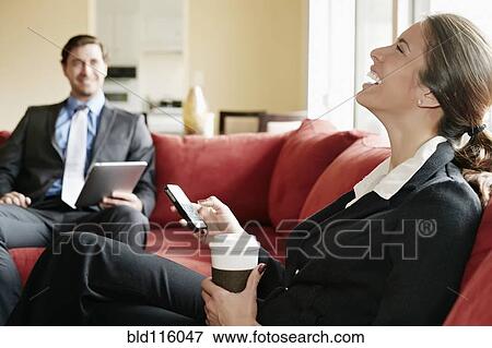 Stock Photo - Business people relaxing on sofa together. Fotosearch