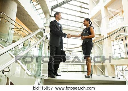 Business people shaking hands in office View Large Photo Image Stock Photo - Business people shaking hands in office. Fotosearch