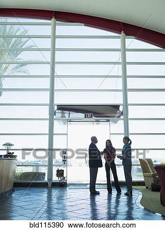 Stock Image - Business people talking in airport. Fotosearch