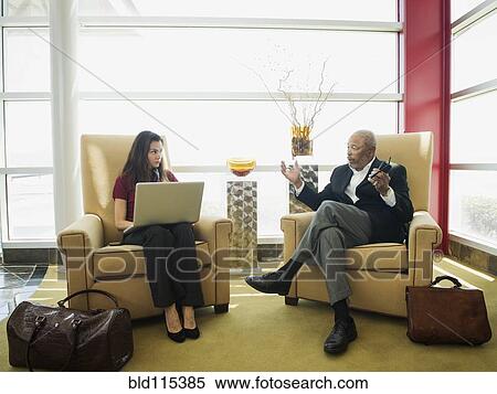 Stock Photography - Business people talking in lobby area. Fotosearch