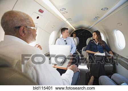 Business people talking on airplane View Large Photo Image Stock Image - Business people talking on airplane. Fotosearch