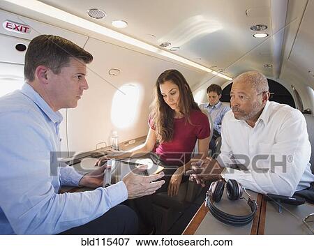 Stock Photo - Business people talking on airplane. Fotosearch
