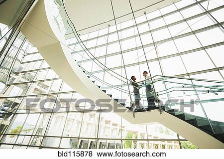 Stock Photo - Business people talking on office staircase. Fotosearch
