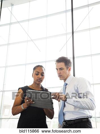 Stock Photograph - Business people using digital tablet. Fotosearch