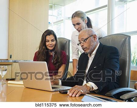 Stock Photography - Business people working on laptop. Fotosearch