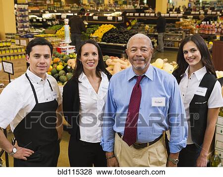 Stock Photo - Businessman and workers smiling in grocery store. Fotosearch
