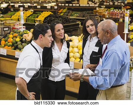 Businessman and workers talking in grocery store View Large Photo Image Stock Image - Businessman and workers talking in grocery store. Fotosearch