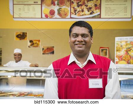Businessman smiling by restaurant counter View Large Photo Image Stock Image - Businessman smiling by restaurant counter. Fotosearch