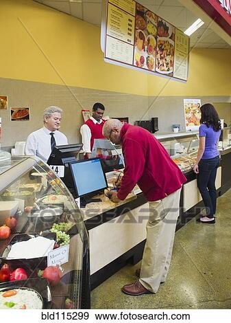 Stock Photo - Businessmen and chef serving customers at restaurant counter. Fotosearch